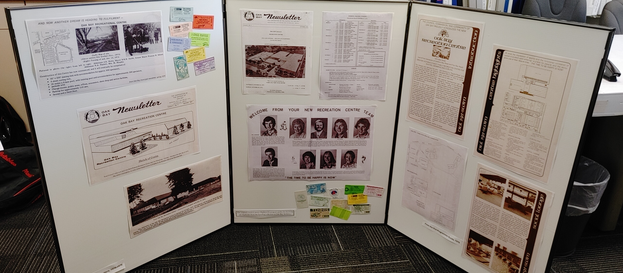 A display board featuring historical documents, newsletters, and images related to the Oak Bay Recreational Centre.